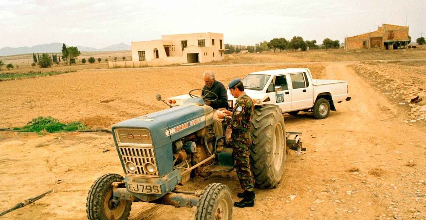 YK:n rauhanturvaaja tarkistaa kyproslaisen maaviljelijän henkilötodistuksen. Kuva: UN Photo/John Isaac  